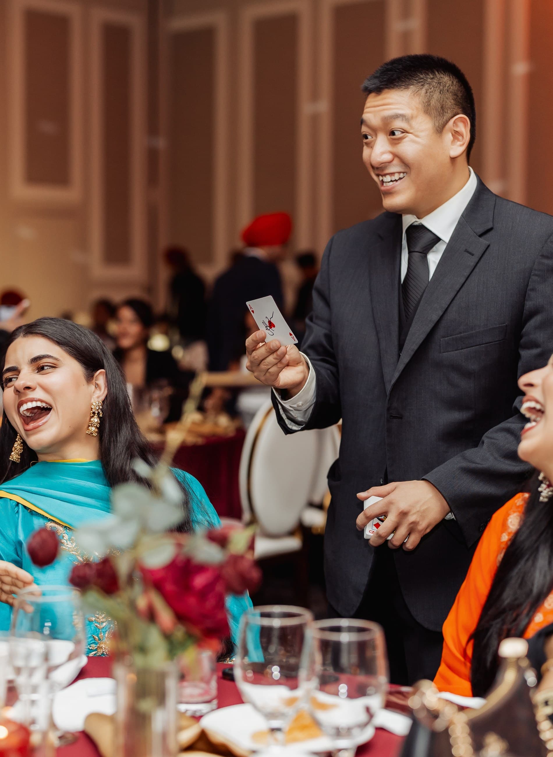John Ha showing close-up magic to laughing guests at an Ontario private dining table
