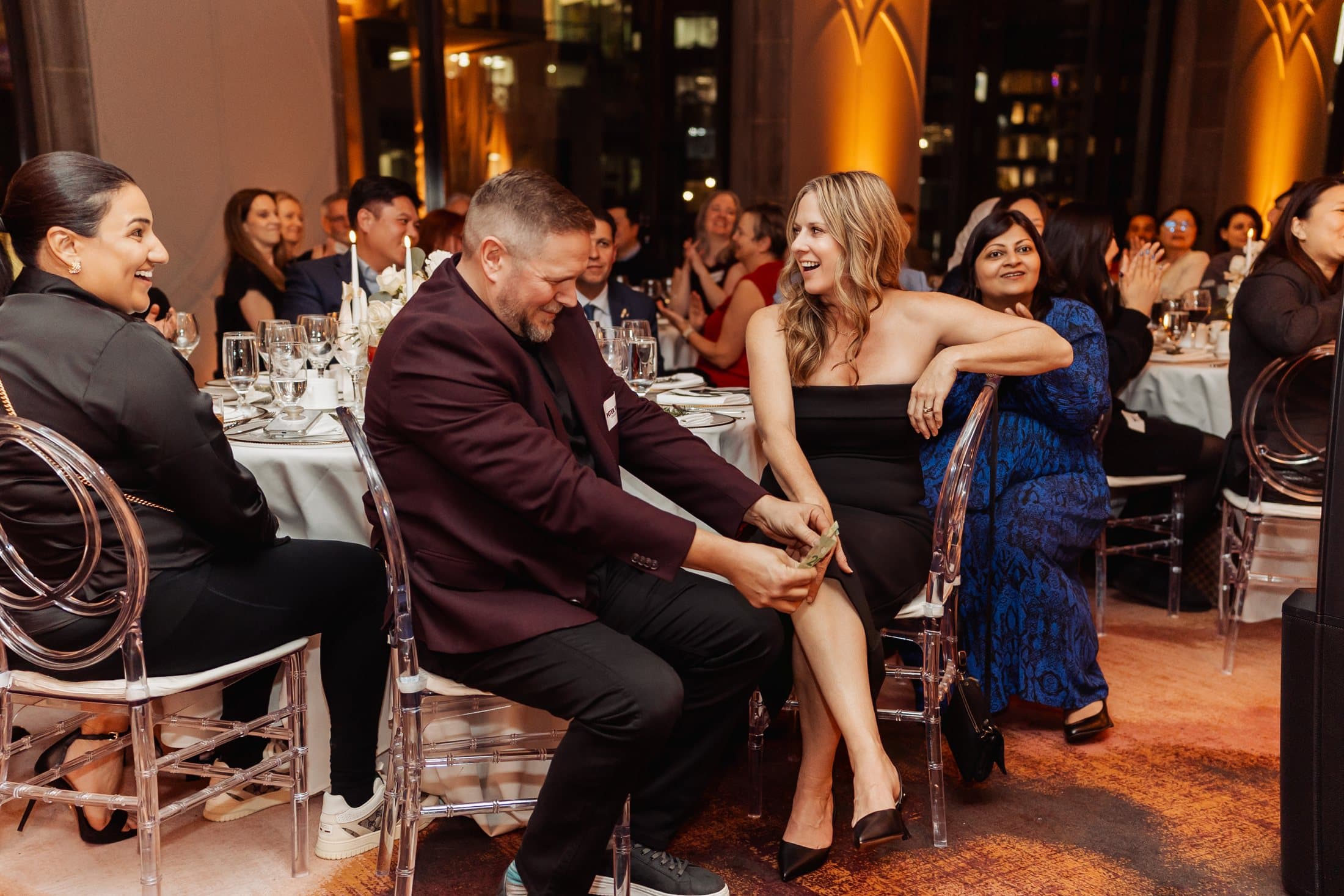 Gala guests reacting while John Ha performs close-up magic
