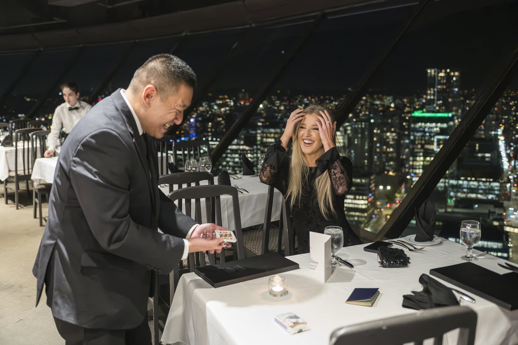 John Ha performing close-up magic for a surprised guest during an Ontario executive retreat dinner