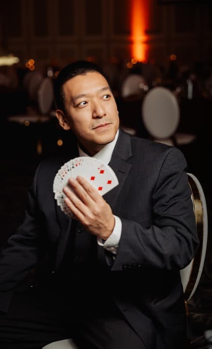 John Ha standing beside a board of client logos