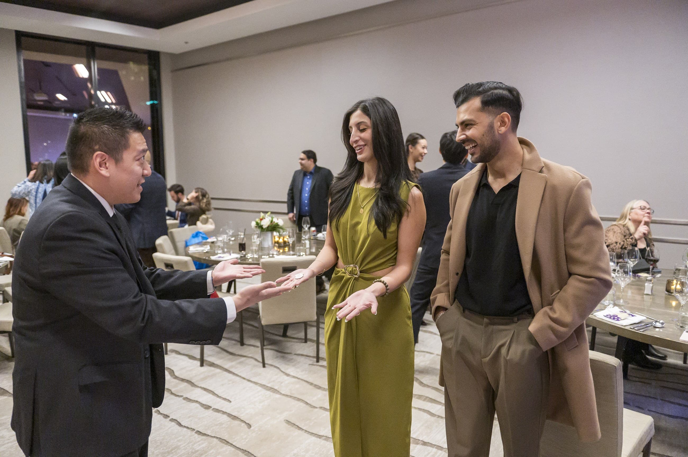 John Ha holding playing cards in formal event attire for Ontario product launch entertainment