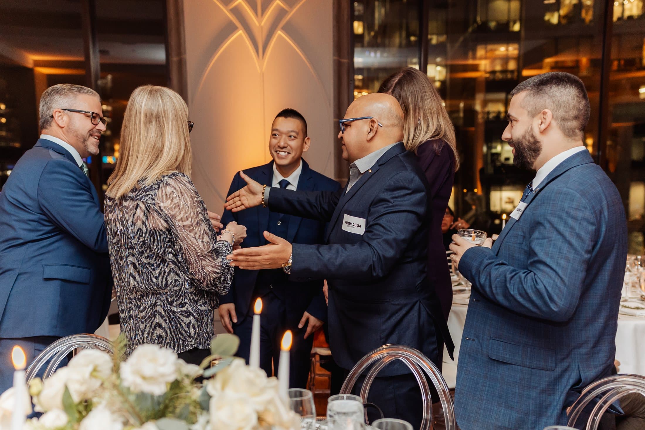 John Ha performing close-up magic for guests reacting at a reception