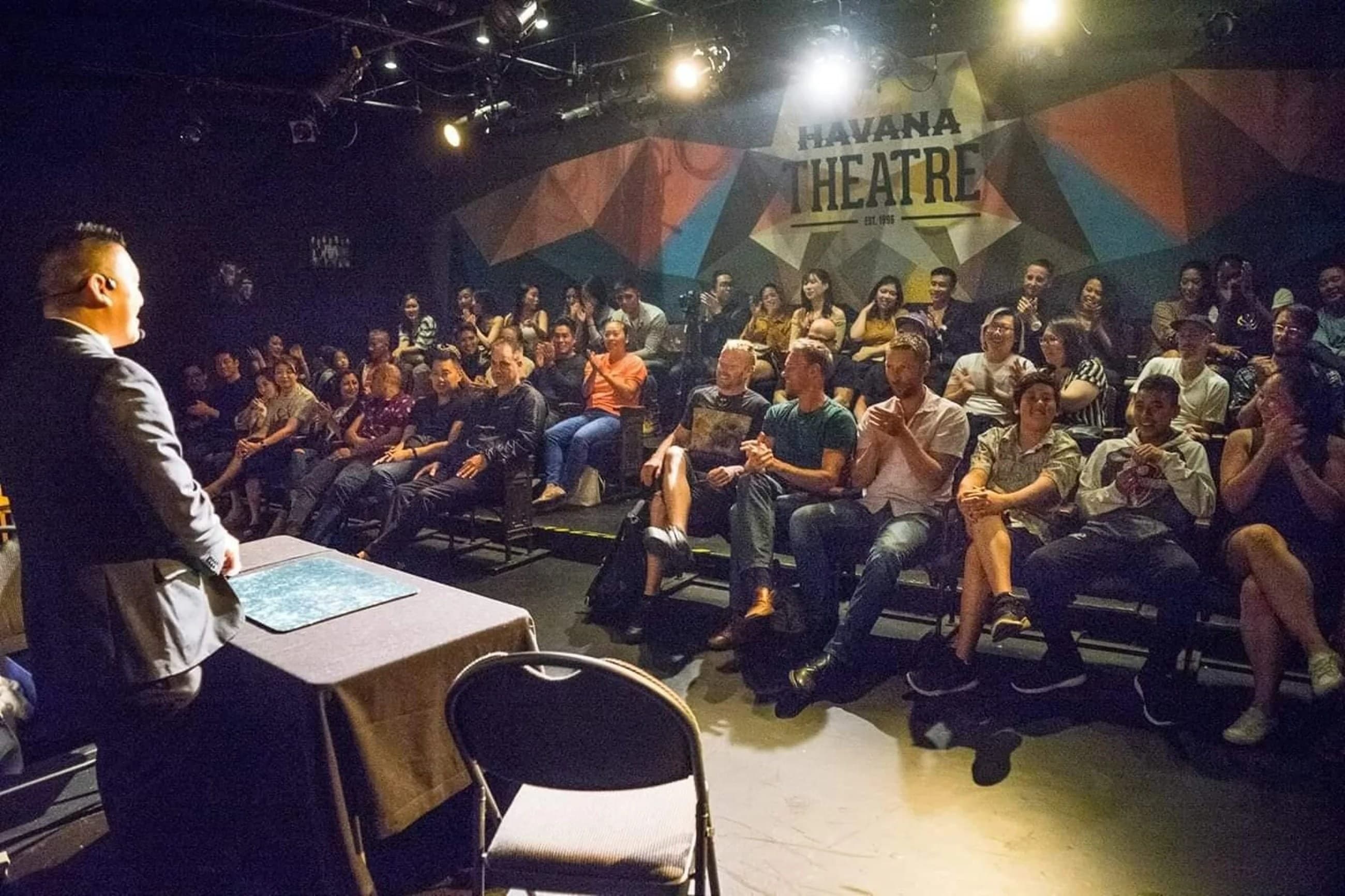 John Ha performing a stand-up magic show for an audience